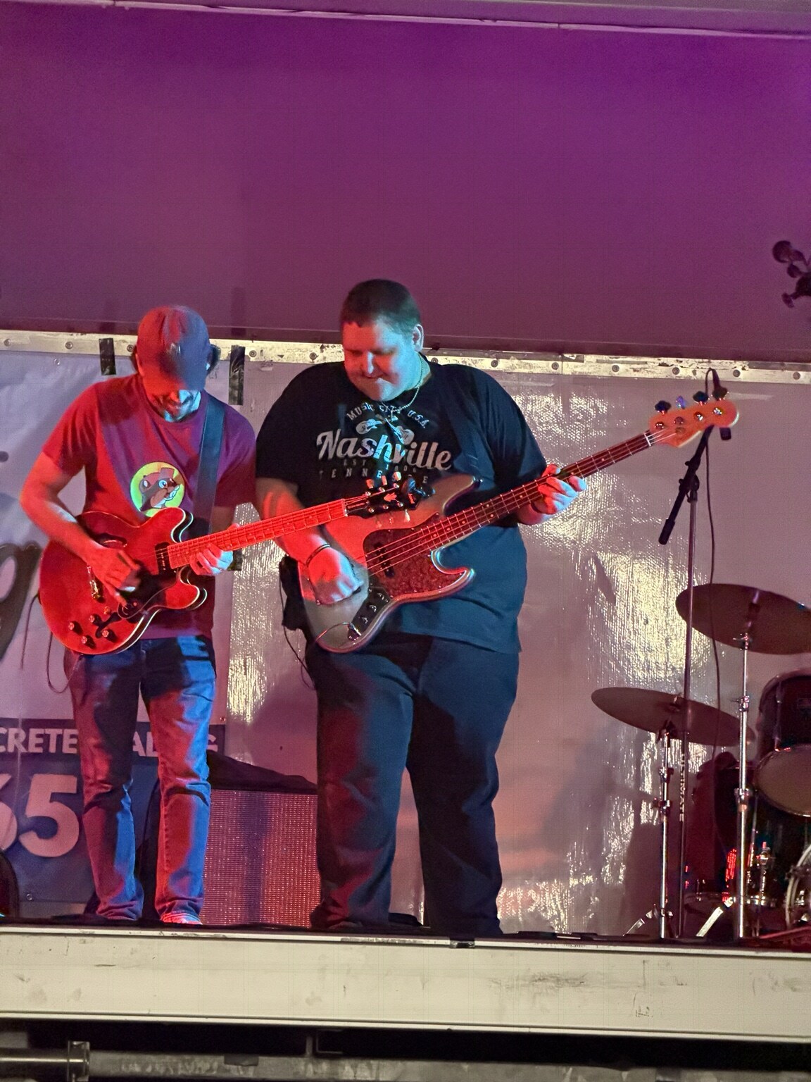 Jayce Walsh playing bass with another guitarist under stage lights